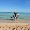 An efoil instructor of the e-Foil Academy Wave Lovers, runs out of the sea in Mallorca in a beautiful bay