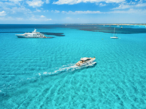 Azure seashore in Formentera with some luxury charter yachts