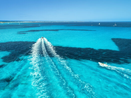 A boat cruises in the beautiful turquoise waters of Mallorca